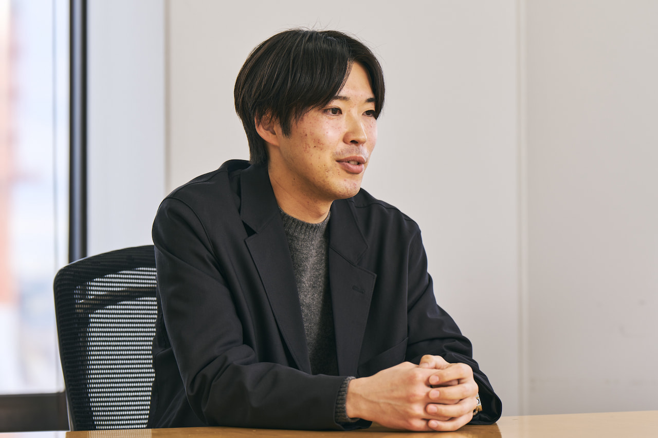 「生産事業所で働いた経験も活かして今の業務に取り組む」（萩原）