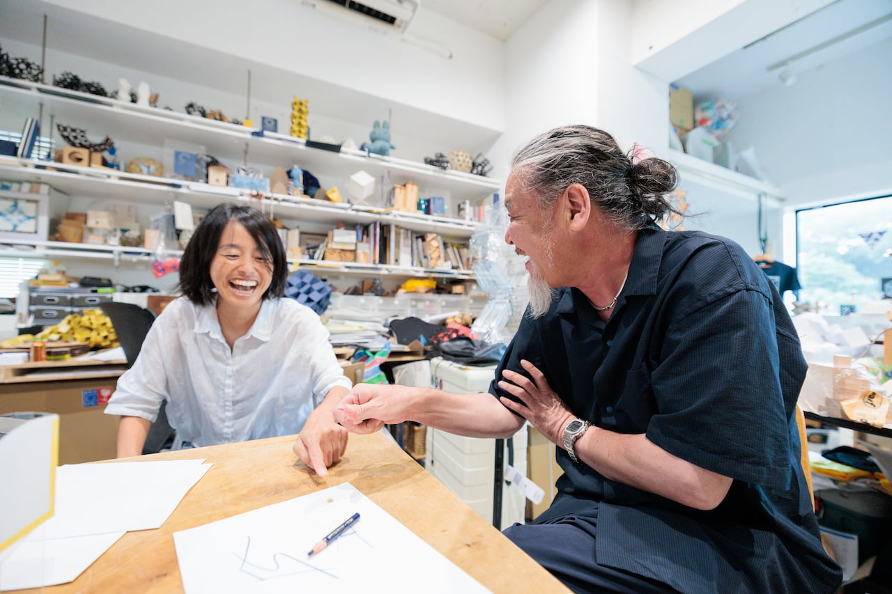 麻魚さんのサンダルに残る鳥取砂丘の砂を紙の上へ。「東京にいながら鳥取を感じる」という話からアイデアが次々と広がる